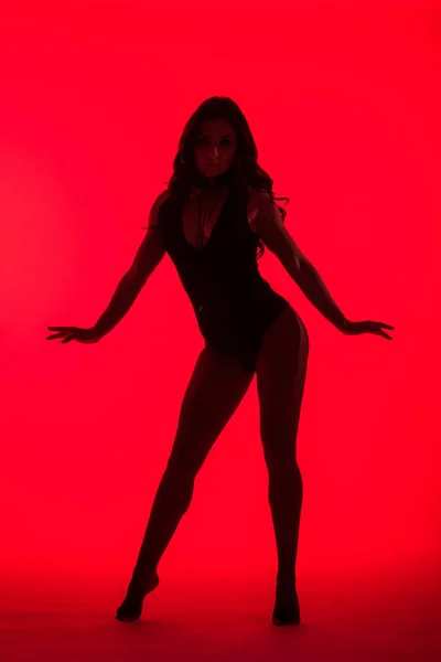 Silhouette di bella giovane donna sexy, isolata sul rosso — Foto stock