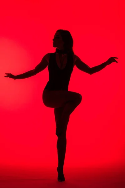 Silhouette di bella ragazza elegante, isolata su rosso — Foto stock