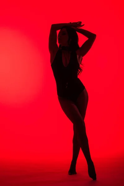 Silhouette of beautiful sensual girl, isolated on red — Stock Photo