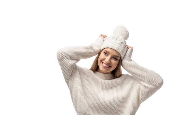 Красива щаслива жінка позує в білому в'язаному светрі і капелюсі, ізольована на білому — стокове фото