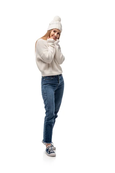 Приваблива жінка позує в джинсах, білий в'язаний светр і капелюх, ізольована на білому — стокове фото