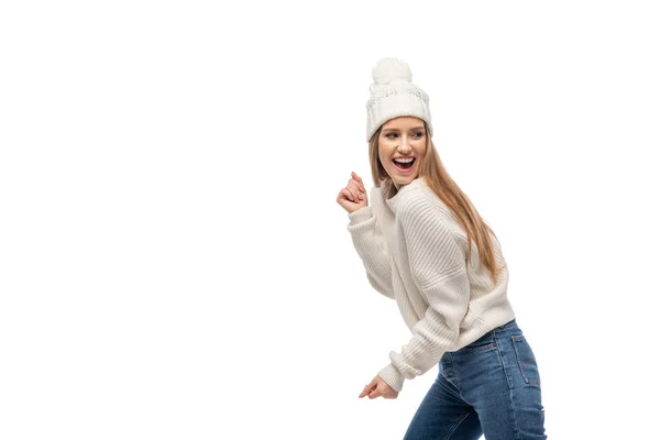 Mujer excitada bailando en suéter y sombrero de punto blanco, aislado en blanco - foto de stock