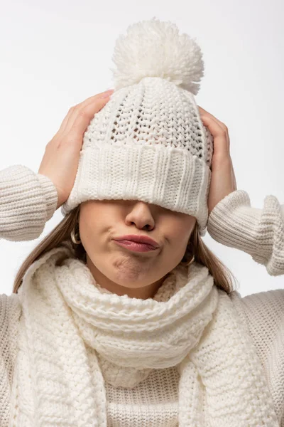 Confused woman warming up in white knitted hat, isolated on white — Stock Photo