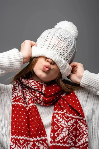 Beautiful girl in knitted scarf with hat on eyes, isolated on grey — Stock Photo