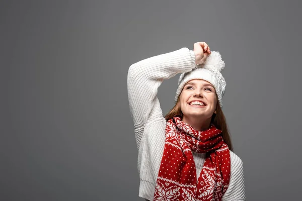 Atractiva mujer sonriente en sombrero de punto y bufanda, aislado en gris - foto de stock