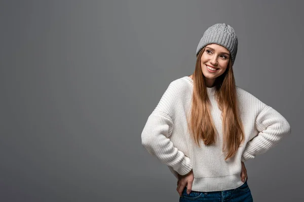 Красивая веселая девушка в вязаной шляпе и свитере, изолированная на сером — стоковое фото