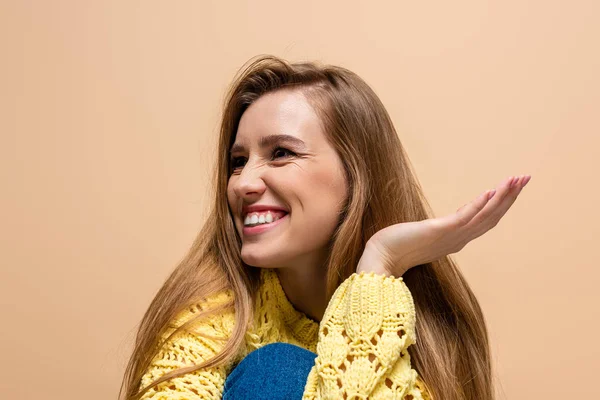 Beautiful positive woman in yellow sweater, isolated on beige — Stock Photo