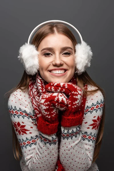 Bela mulher sorridente em camisola de Natal, cachecol, mitenes e auriculares, isolado em cinza — Fotografia de Stock