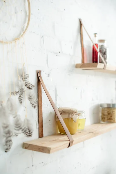 Close up of dream catcher and wooden shelves with jars in kitchen — Stock Photo