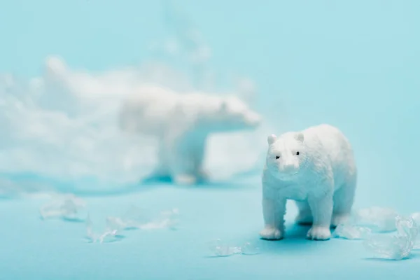 Ursos polares de brinquedo com lixo de polietileno em fundo azul, conceito de poluição ambiental — Fotografia de Stock