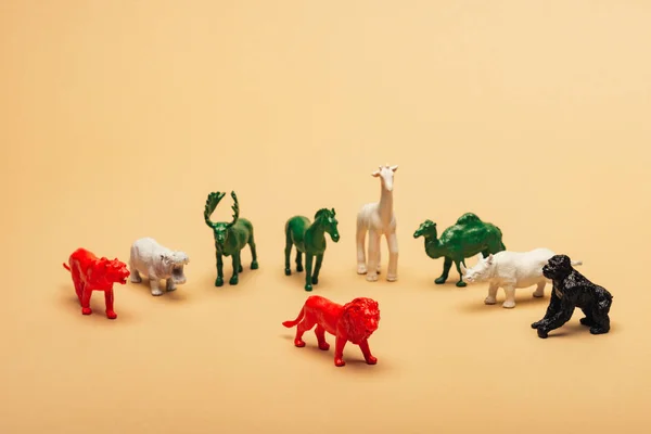 Lion rouge avec des animaux jouets colorés sur fond jaune, concept d'extinction des animaux — Photo de stock