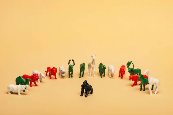 Toy gorilla with colored animals on yellow background, extinction of animals concept — Stock Photo
