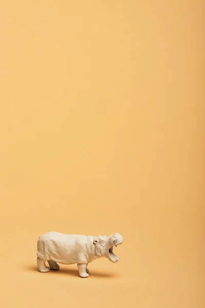 Brinquedo branco hipopótamo no fundo amarelo, conceito de bem-estar animal — Fotografia de Stock