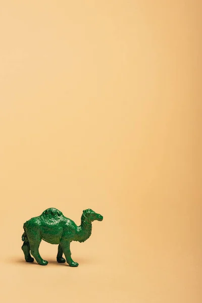 Camelo de brinquedo verde no fundo amarelo, conceito de bem-estar animal — Fotografia de Stock