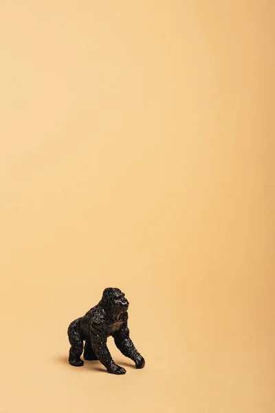 Black toy gorilla on yellow background, animal welfare concept — Stock Photo