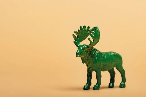 Green toy moose on yellow background, animal welfare concept — Stock Photo