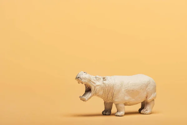 White toy hippopotamus on yellow background, animal welfare concept — Stock Photo