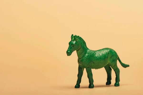 Grünes Spielzeugpferd auf gelbem Hintergrund, Tierschutzkonzept — Stockfoto