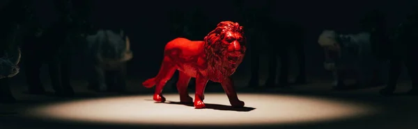 Panoramic shot of red toy lion under spotlight with animals at background, voting concept — Stock Photo