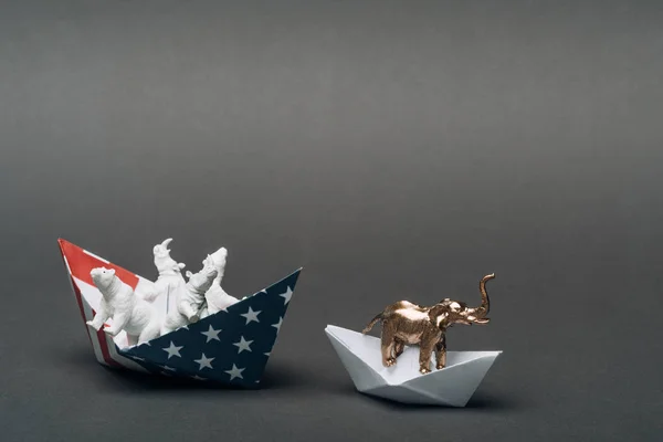 Toy elephant in paper boat and animals in boat from american flag on grey background, animal welfare concept — Stock Photo