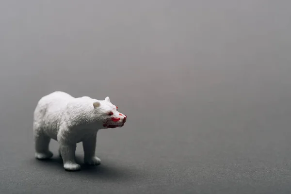Біла іграшка має кров на сірому тлі, вбиваючи тварин. — стокове фото