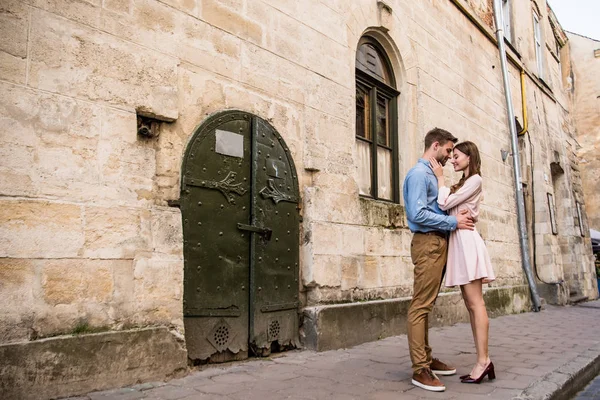Couple de jeunes touristes embrassant tout en se tenant près du vieux château de pierre — Photo de stock