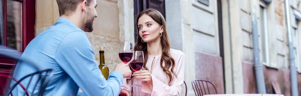 Coppia di giovani turisti seduti in strada caffè e bicchieri di vino rosso — Foto stock