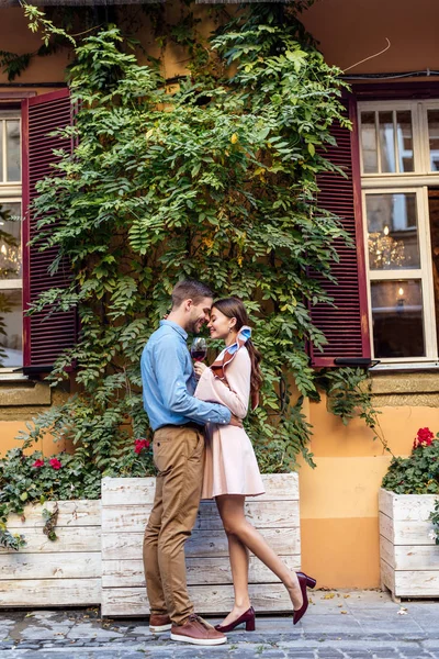 Side view of happy young couple embracing while standing near house covered with green ivy — Stock Photo