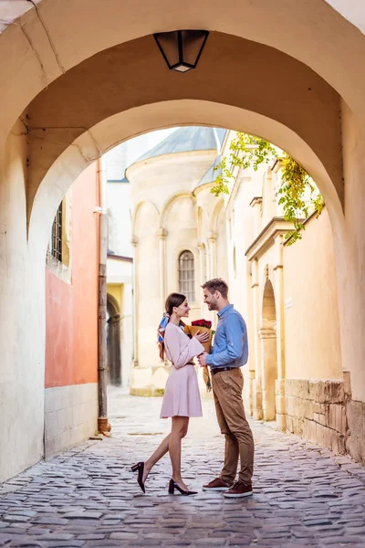 Vista laterale dell'uomo che presenta mazzo di rose mentre fa la proposta di matrimonio alla fidanzata in strada — Foto stock