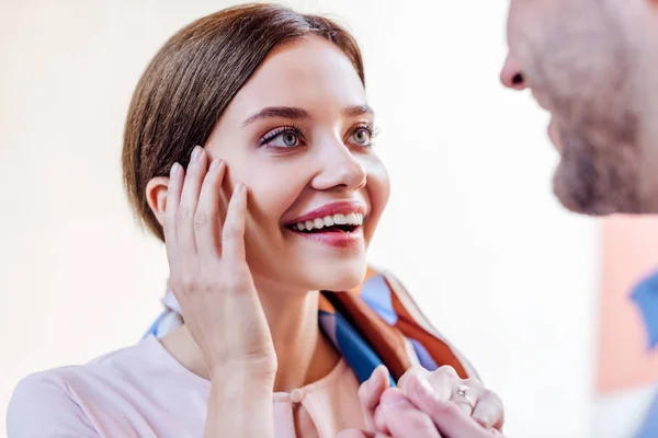 Felice, eccitato giovane donna guardando fidanzato e tenendo la mano vicino al viso — Foto stock