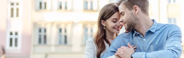 Plan panoramique de fille heureuse embrassant beau petit ami dans la rue — Photo de stock