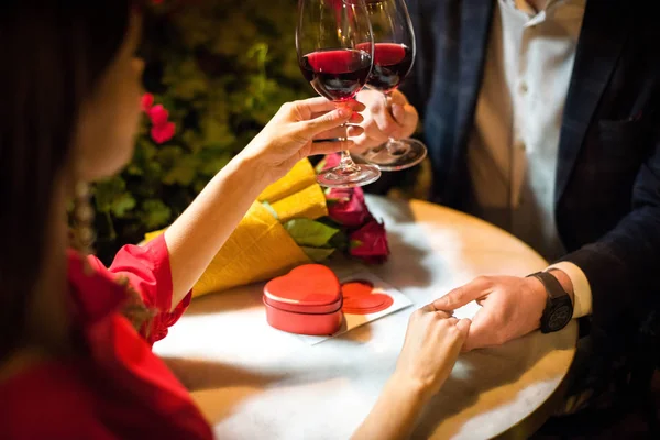 Visão parcial do homem clinking copos de vinho tinto com a namorada ao fazer proposta de casamento — Fotografia de Stock