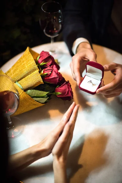 Cropped view of man presenting wedding ring to girlfriend while making marriage proposal — Stock Photo
