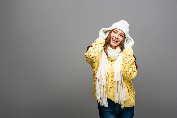 Happy girl in yellow sweater, scarf, hat and gloves on grey — Stock Photo