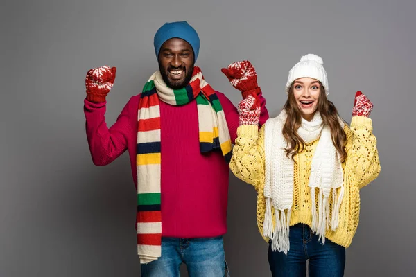 Feliz casal interracial no inverno roupa mostrando sim gesto no fundo cinza — Fotografia de Stock
