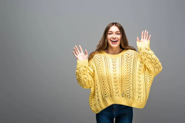 Aufgeregte, glückliche Frau im gelben Pullover auf grauem Hintergrund — Stockfoto