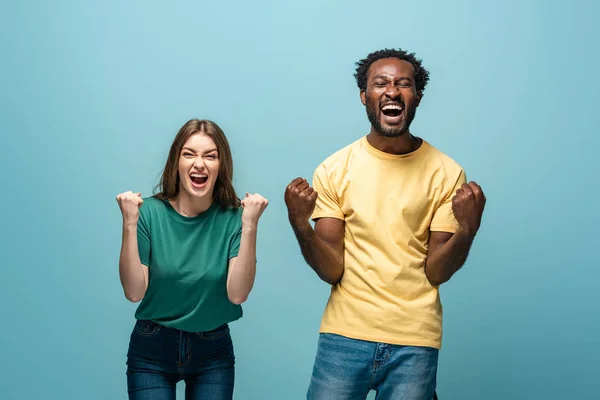 Glückliches gemischtrassiges Paar zeigt Ja-Geste auf blauem Hintergrund — Stockfoto