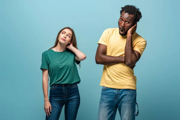 Dreamy interracial couple on blue background — Stock Photo