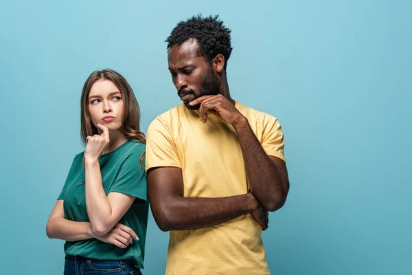 Pensativo casal interracial no fundo azul — Fotografia de Stock