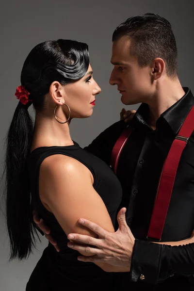 Deux danseurs passionnés exécutant le tango face à face isolé sur gris — Photo de stock