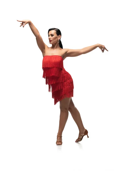 Graceful dancer in elegant dress with fringe performing tango on white background — Stock Photo