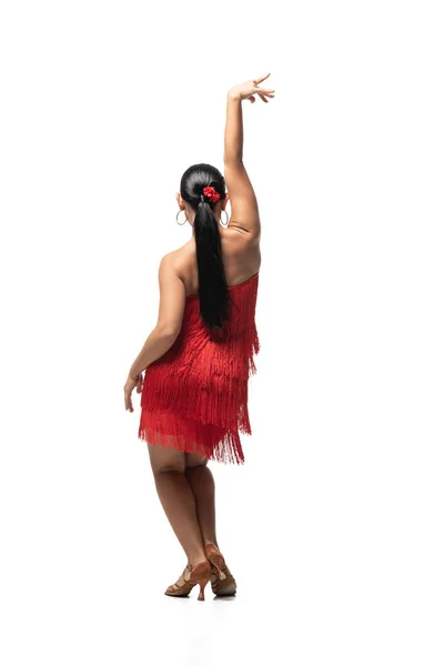 Vista posterior de bailarina expresiva en vestido elegante con franja realizando tango sobre fondo blanco - foto de stock