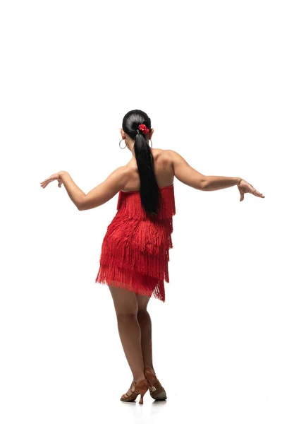 Vista posterior de bailarina apasionada en vestido elegante con franja realizando tango sobre fondo blanco - foto de stock