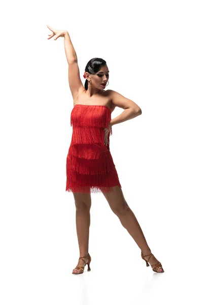 Beautiful, passionate dancer in red dress with fringe performing tango on white background — Stock Photo
