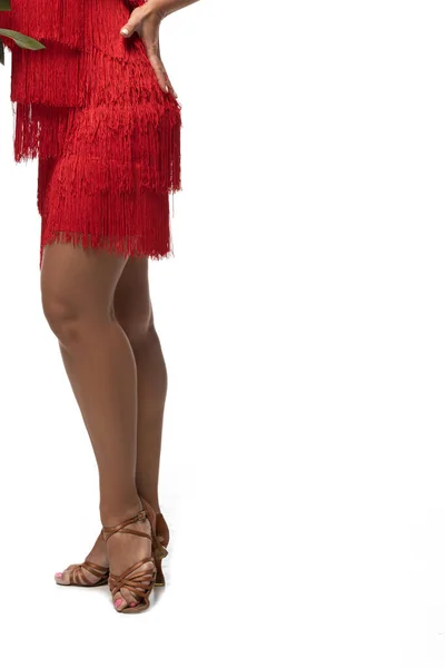 Vista recortada de bailarina de tango en sandalias y vestido rojo con flecos sobre fondo blanco — Stock Photo