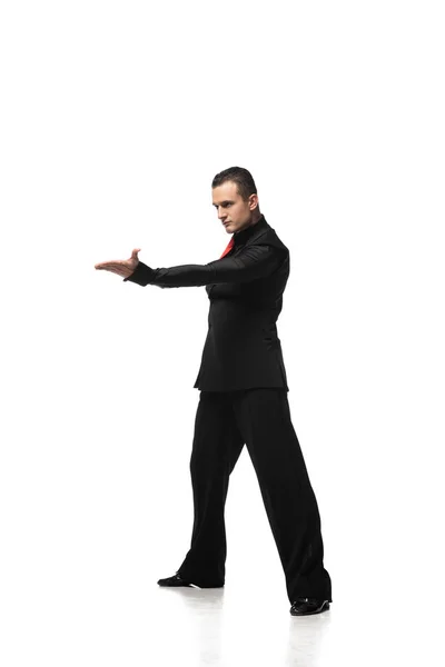 Танцовщица танго в элегантном черном костюме приглашает танцевать на белом фоне — стоковое фото