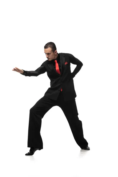 Passionate tango dancer in elegant black suit inviting to dance on white background — Stock Photo