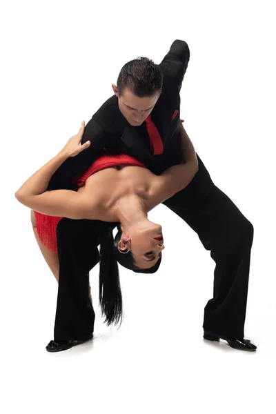 Dançarino elegante apoiar atraente, parceiro apaixonado durante a realização de tango no fundo branco — Fotografia de Stock
