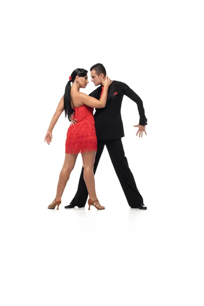 Elegant dancers looking at each other while performing tango on white background — Stock Photo