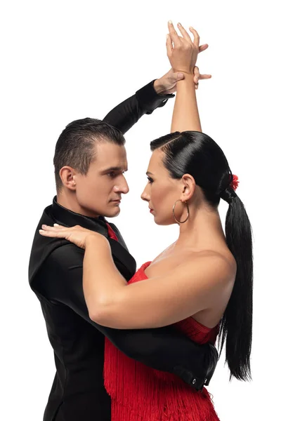 Bailarines apasionados mirándose mientras realizan tango aislado en blanco - foto de stock